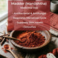 Madder powder in a wooden bowl with text about its medicinal properties on a rustic background.