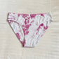 Pink and white tie-dye underwear on a light beige surface
