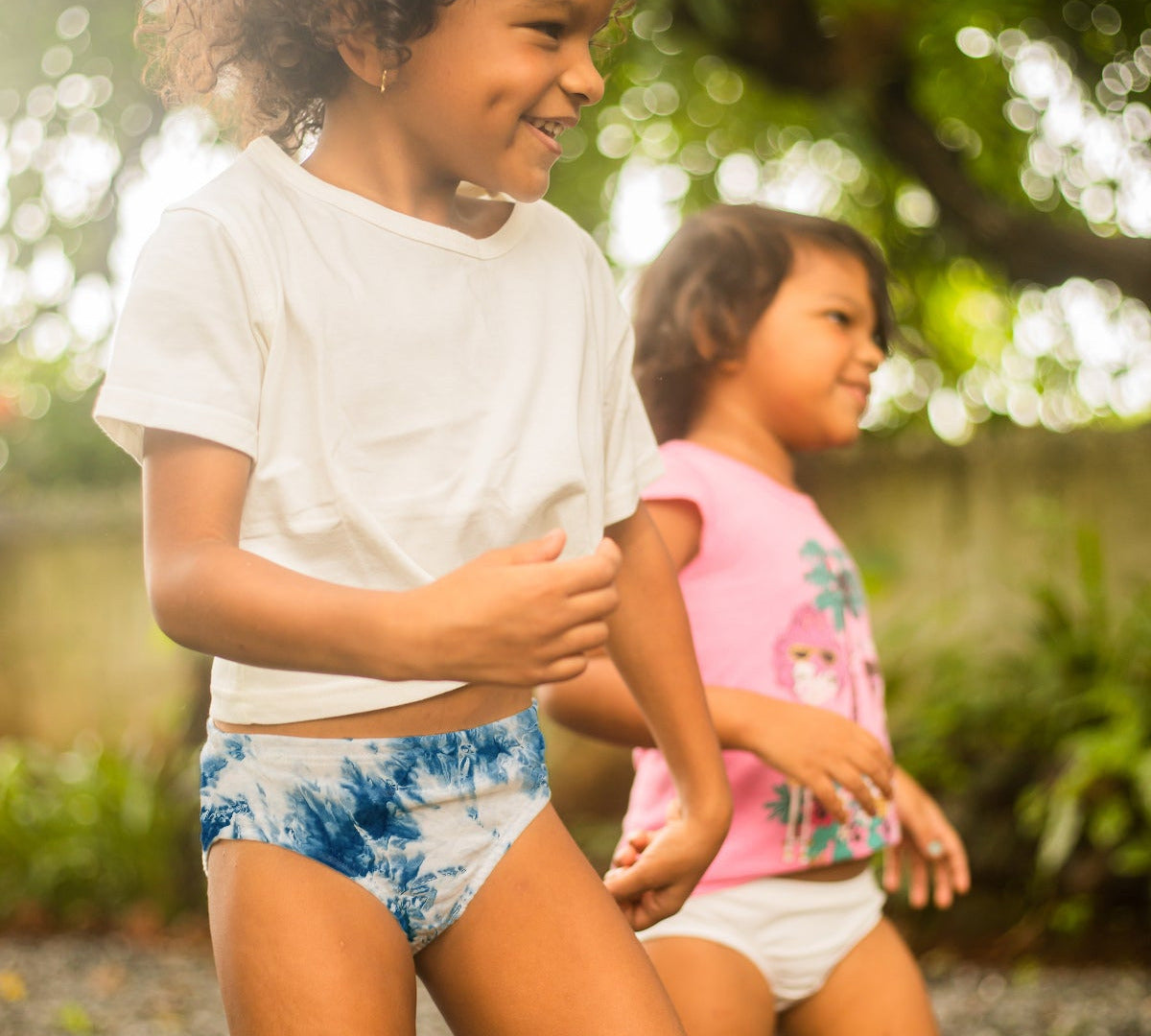 Two children playing outdoors with a blurred natural background