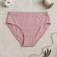 Pink underwear on a textured beige surface with cotton bolls and twine.